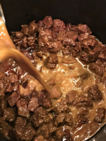 This is a photo of Beef Tips cooking in a black pot.