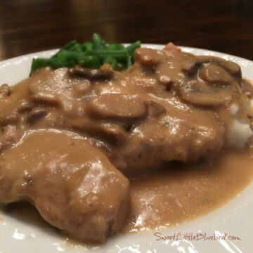 This is a photo of Slow Cooker Smothered Pork Chops served over mashed potatoes with the gravy.