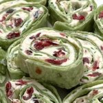 Cranberry Jalapeño Pinwheels stacked on a plate.