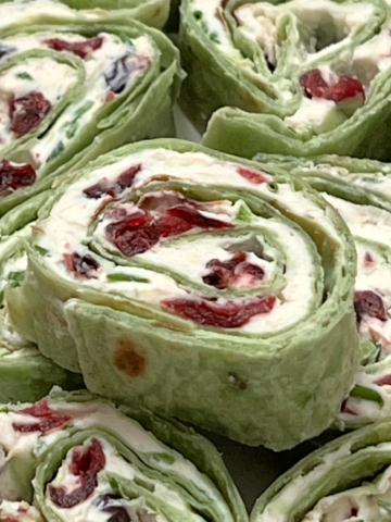 Cranberry Jalapeño Pinwheels stacked on a plate.