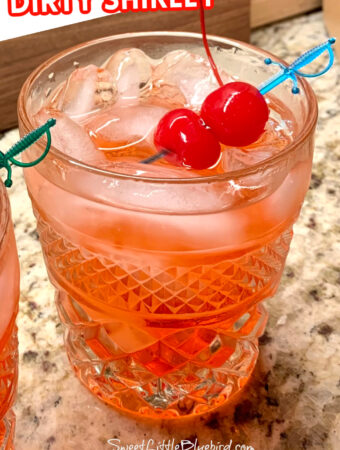 Photo of glass of Dirty Shirley garnished with two maraschino cherries.