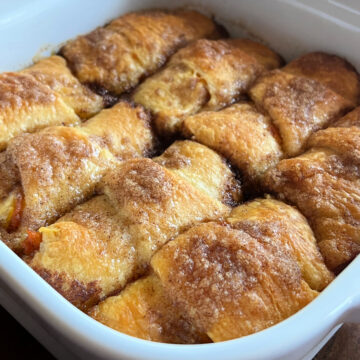 Photo of Pumpkin Crescent Roll Dumplings baked in a white square baking dish.