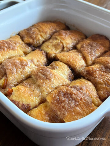 Photo of Pumpkin Crescent Roll Dumplings baked in a white square baking dish.