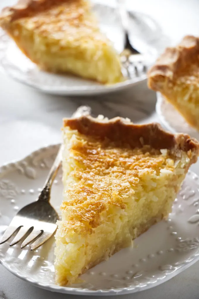 This image shows a slice of French Coconut Pie on a plate with a fork.