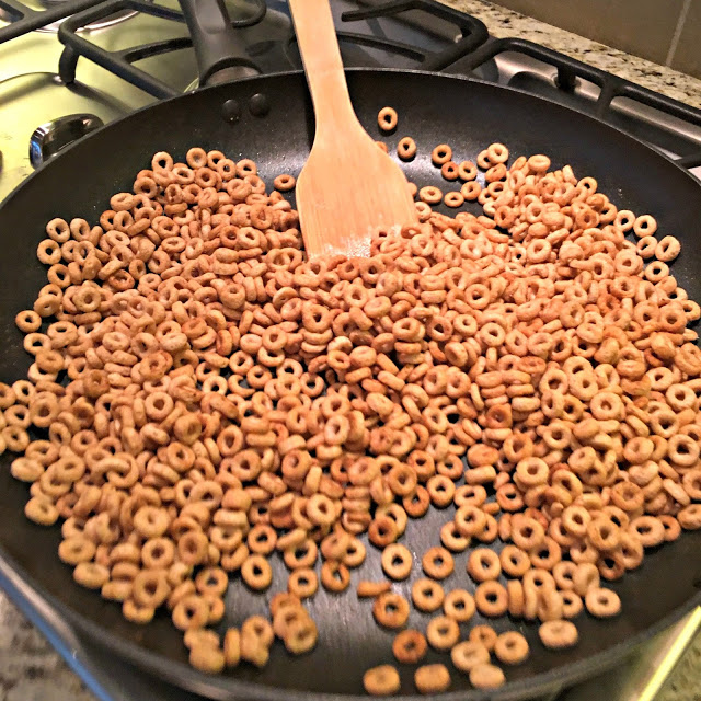 This is a photo of Hot Buttered Cheerios cooking in a large skillet on the stove.