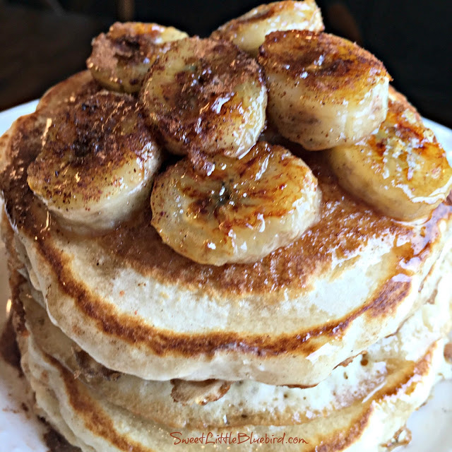 This photo shows fried bananas served on top of a stack of 3 pancakes. 