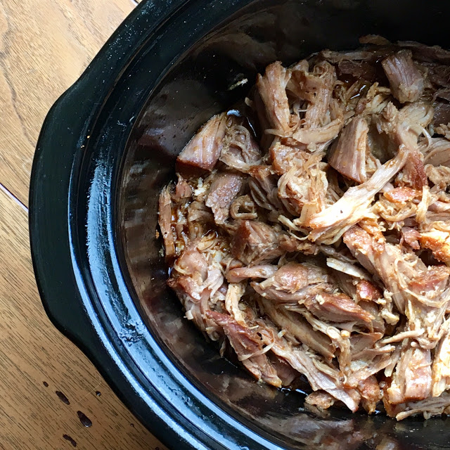 This photo shows the pork in the slow cooker shredded/pulled after cooking, ready to serve. 