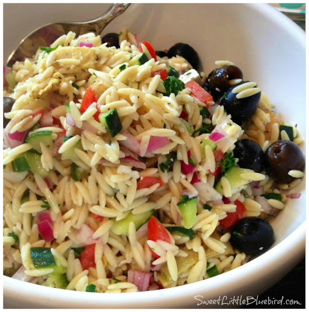 This is a photo of Greek Orzo Salad served in a white bowl. 