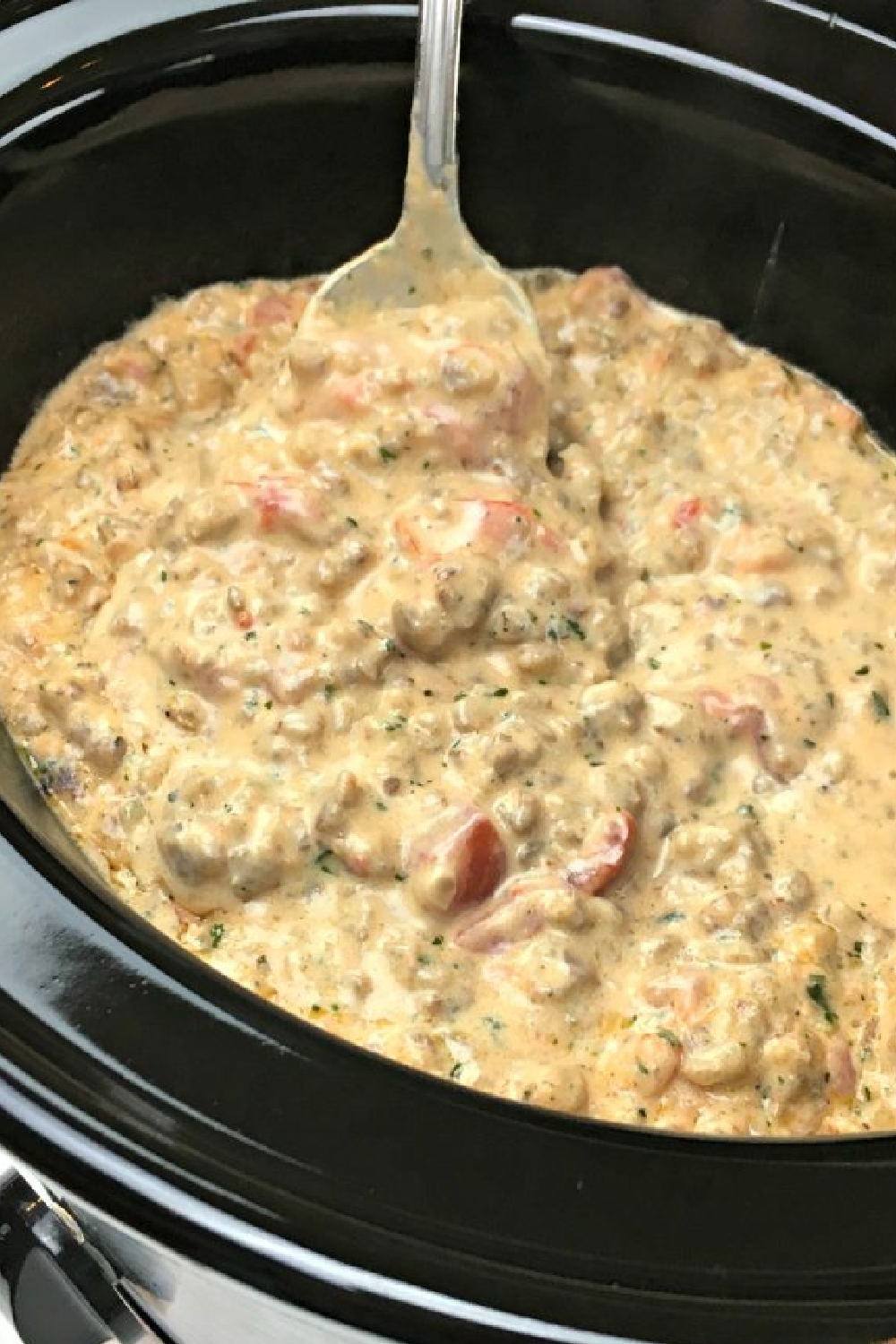 This photo shows Hot Ranch Sausage Dip served in a crock pot/slow cooker. 