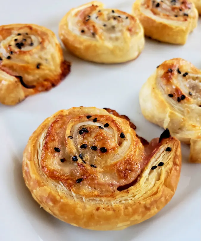 Photo of baked Ham and Cheese Pinwheels on a white plate by Julia’s Simple Southern