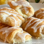 This is a photo of Lemon Cheesecake Crescent Rolls served on a white plate.