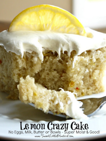 This is a photo showing a piece of Lemon Crazy Cake on a white plate with a fork filled with a bite of the cake, ready to eat.