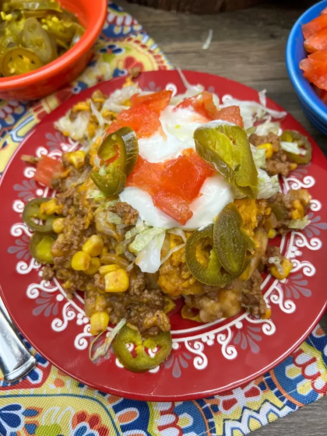 Easy Mexican Ground Beef Casserole served on a red plate by Back To My Southern Roots