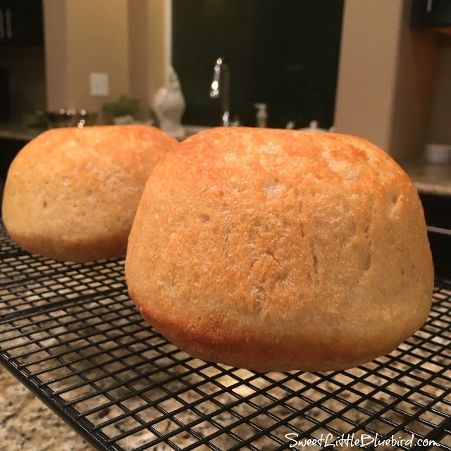 This is a photo showing 2 loafs of peasant bread cooling on a cooling rack.