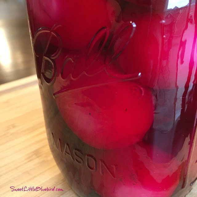 This image shows the pickled eggs and beets in a mason jar. 