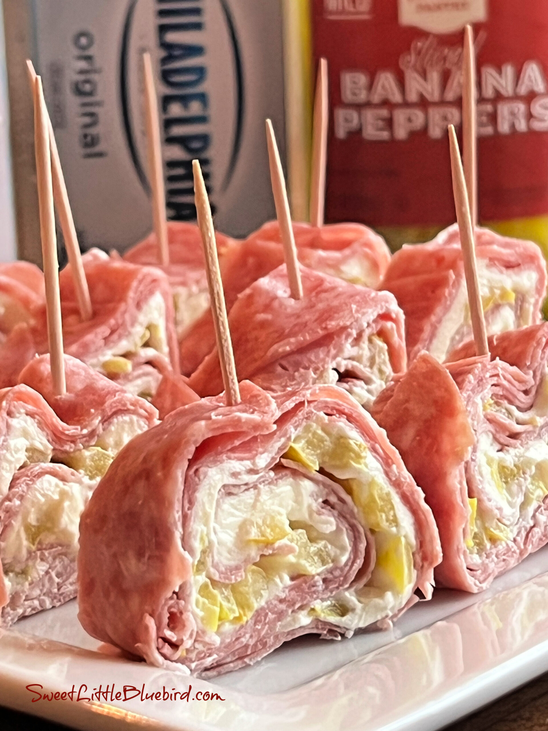 This photo shows the Salami Cream Cheese Roll-ups served on a white platter.