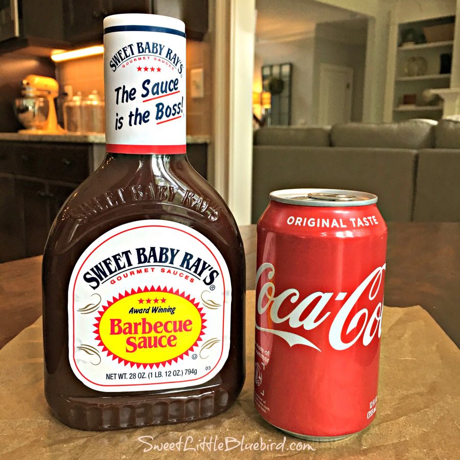 Photo of a bottle of Sweet Baby Ray's Barbecue Sauce and a can of Coca Cola.