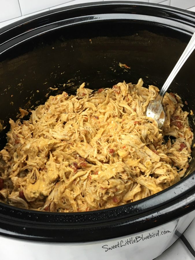 This is a photo of the chicken inside the crockpot pan finished cooking, shredded, queso mixed in and ready to serve.