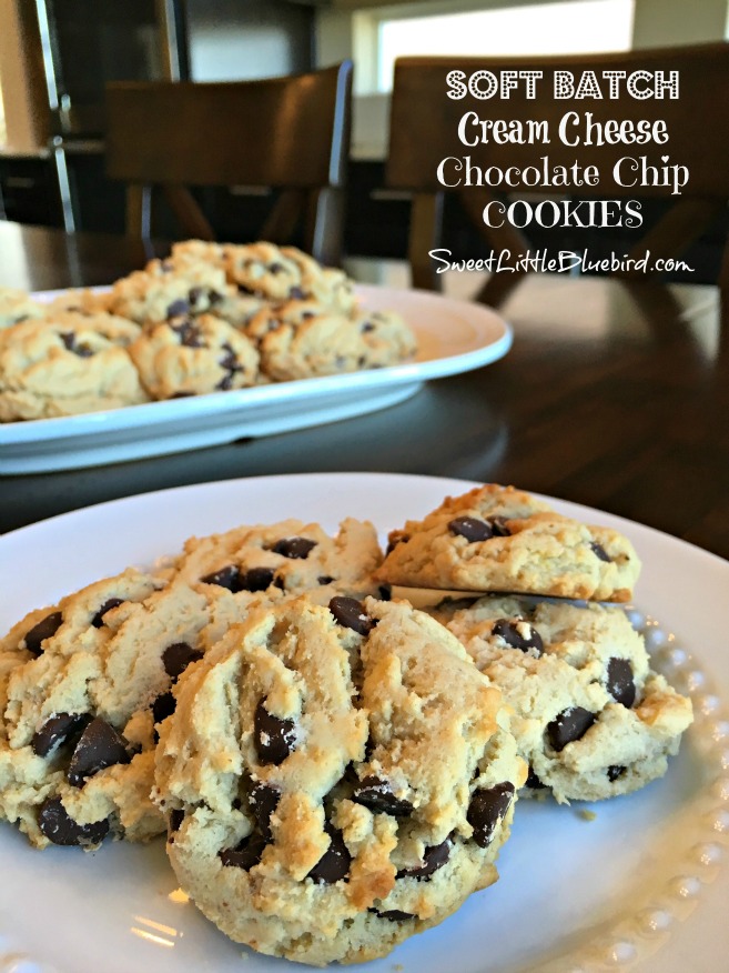 This is a photo of soft batch cream cheese chocolate chip cookies served on a white round plate, ready to eat, with a platter of the cookies behind the plate. 