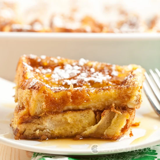 This photo shows two pieces of French Toast Bake, served on a white plate.
