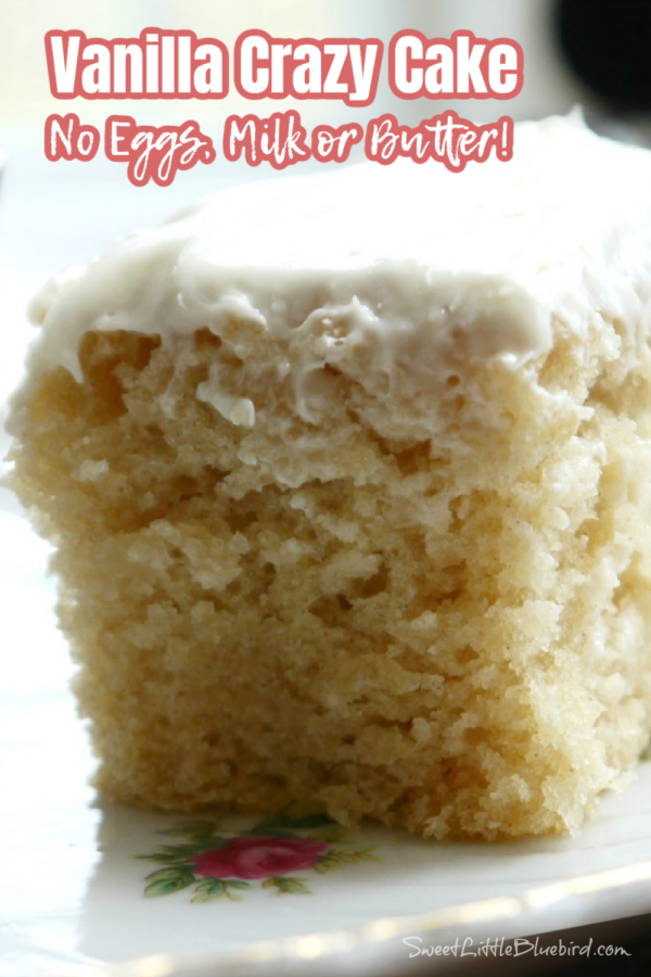 This is a close up photo of vanilla crazy cake served on a plate topped with vanilla frosting.