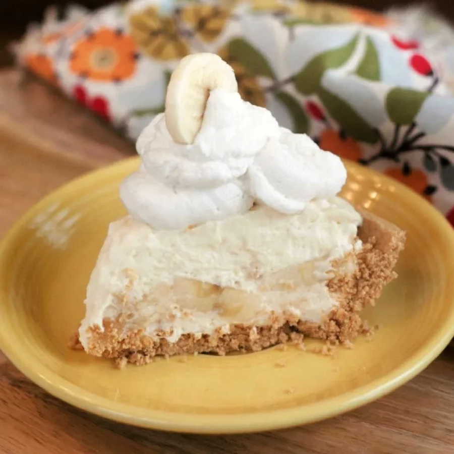 Photo of a slice of banana cream pie on a yellow plate by Cooking with Carlee.