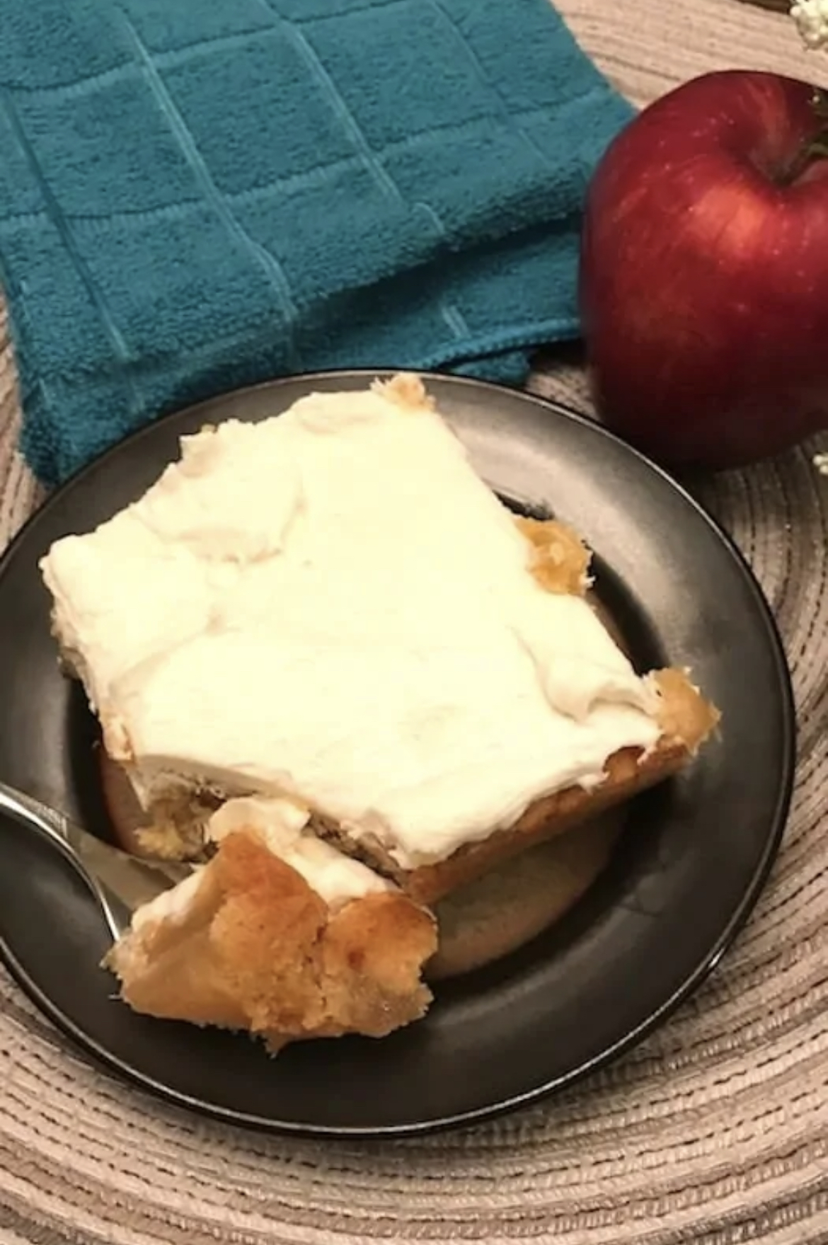 This image shows a piece of apple cake on a plate. 