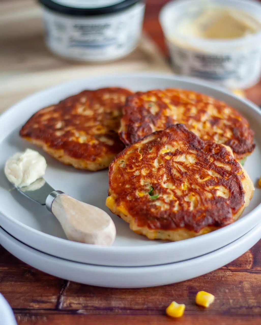 Three Corn Fritters on a white plate. 