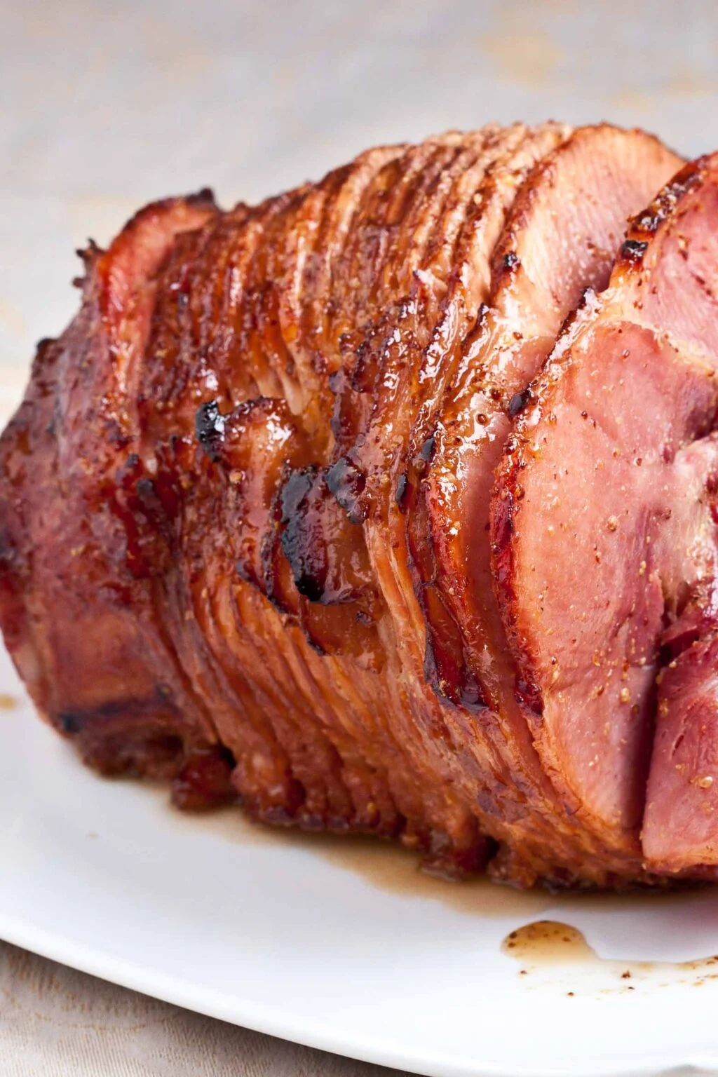 This image shows a Honey Baked Ham on a white platter. 