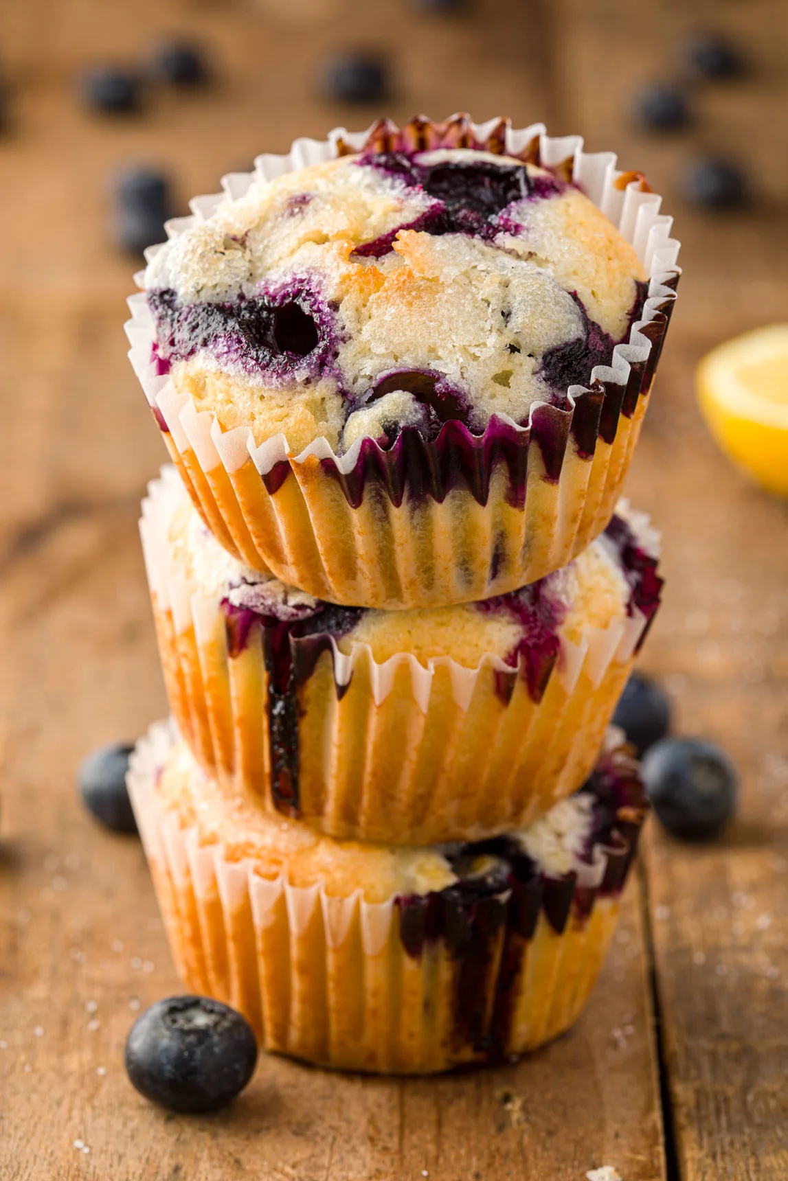 This image shows 3 lemon blueberry muffins stacked on top of each other.