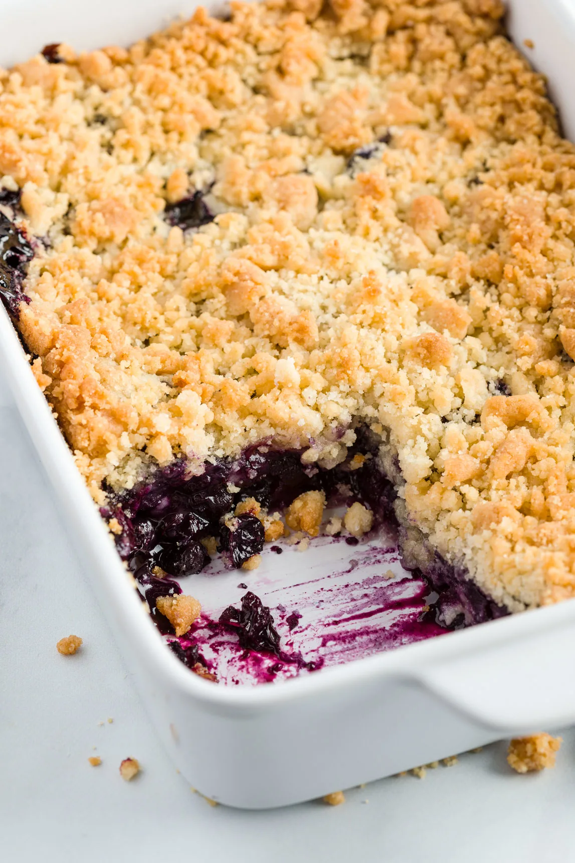 This image shows Blueberry Crisp in a white baking dish. 