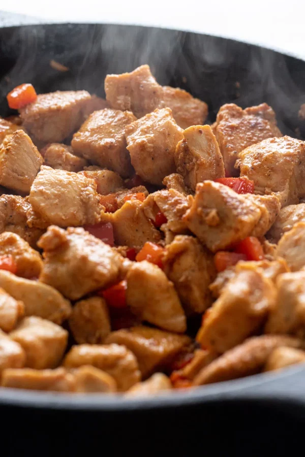 Photo of Cajun Chicken Bites cooking in a Cast Iron Pan.