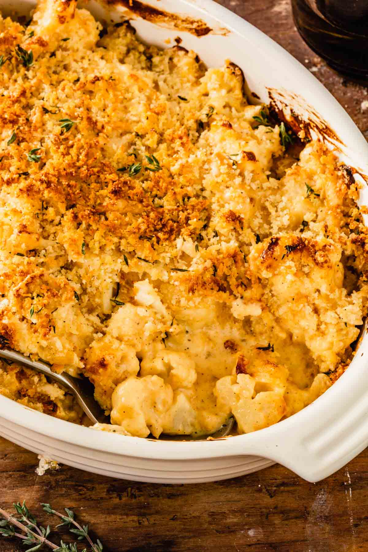 This is a photo showing Cauliflower au Gratin in an off white oval baking dish after baking, ready to serve. 
