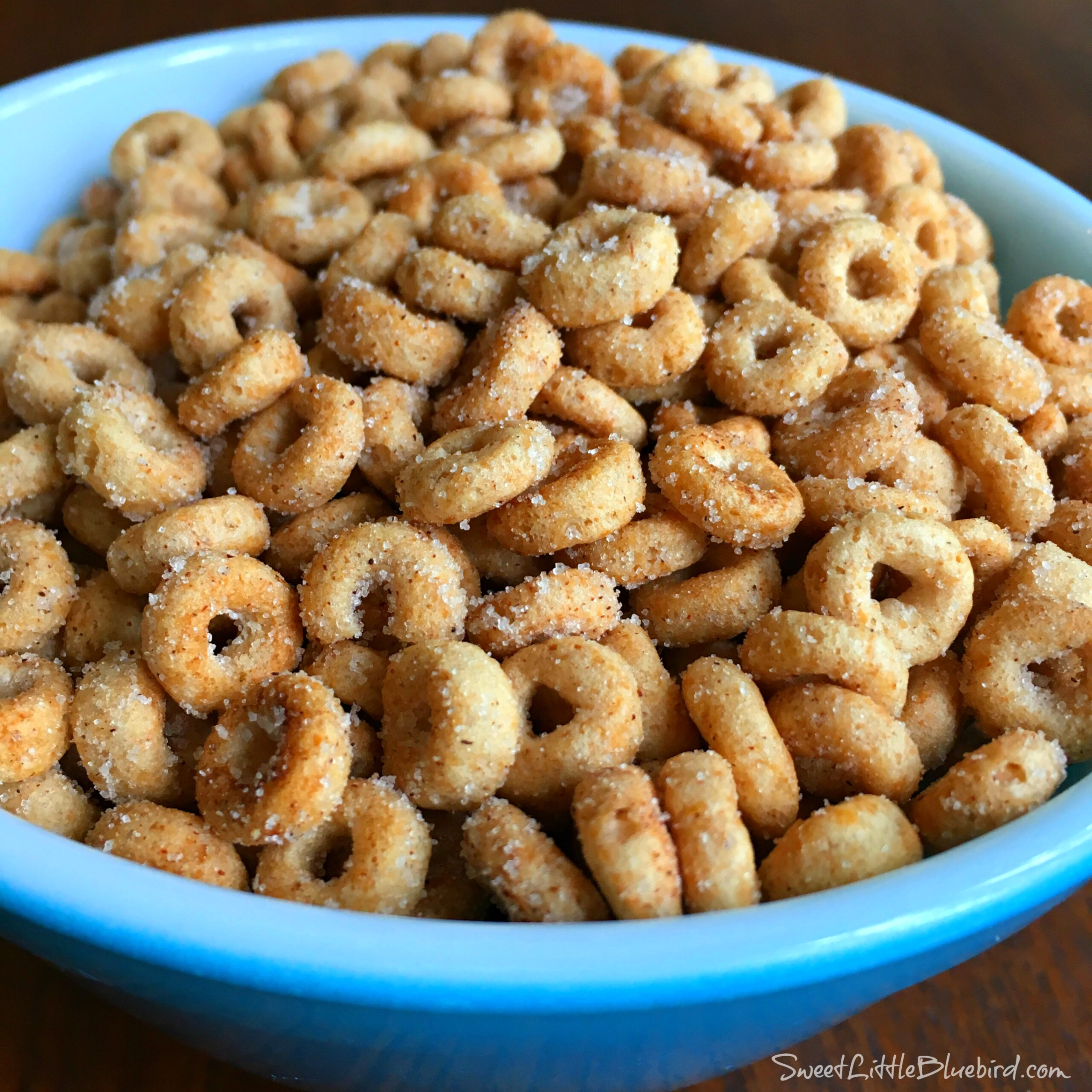 This is a photo of Mini Doughnut Hot Buttered Cheerios served in a blue bowl. 