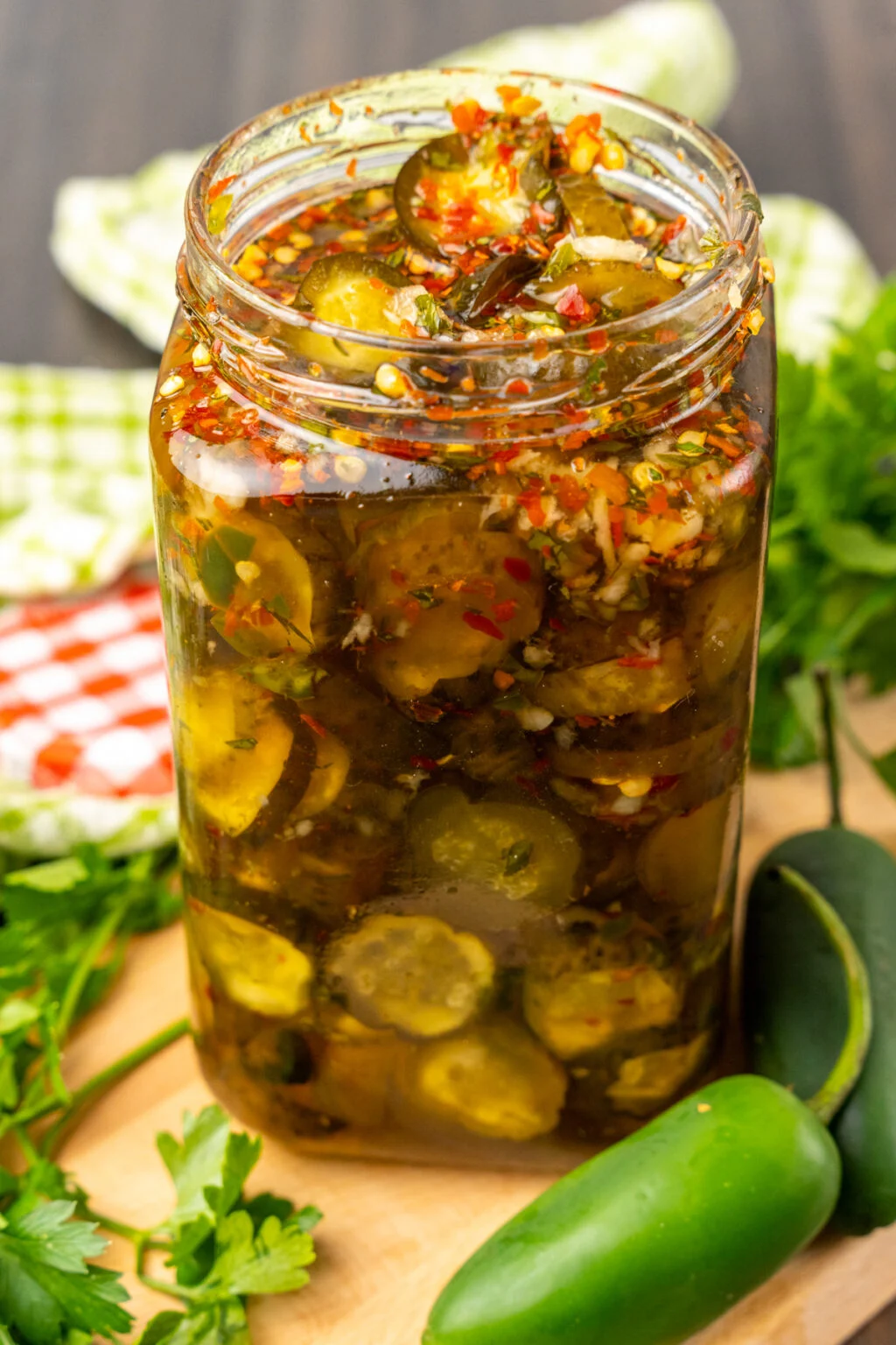 This photo shows a clear canning jar filled with Sweet Heat Pickles. 