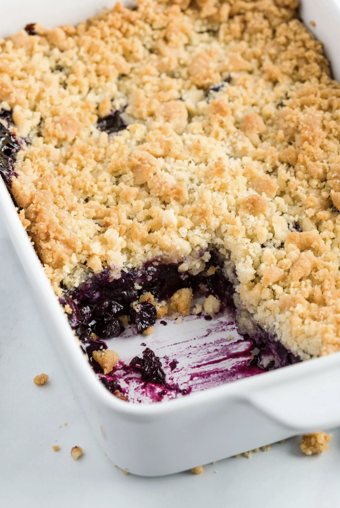 This image shows Blueberry Cobbler in a white baking dish, ready to serve. 