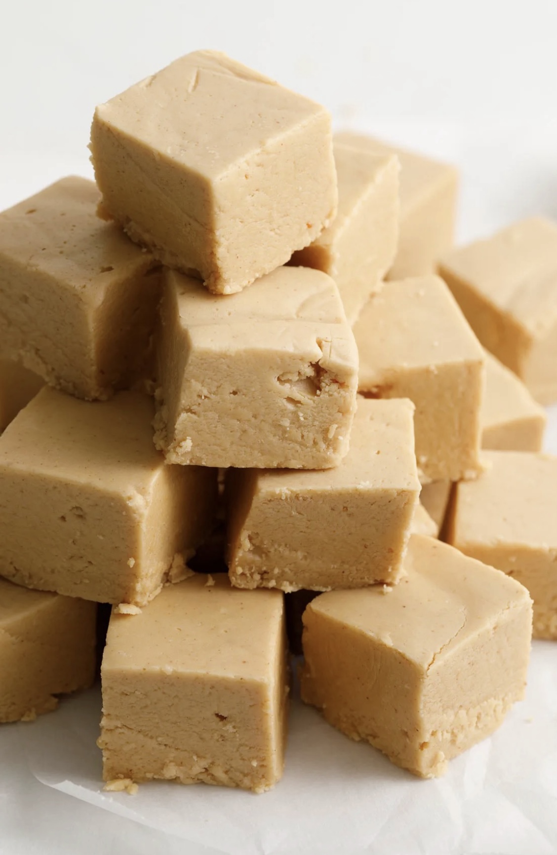Peanut Butter Fudge stacked on a white plate.