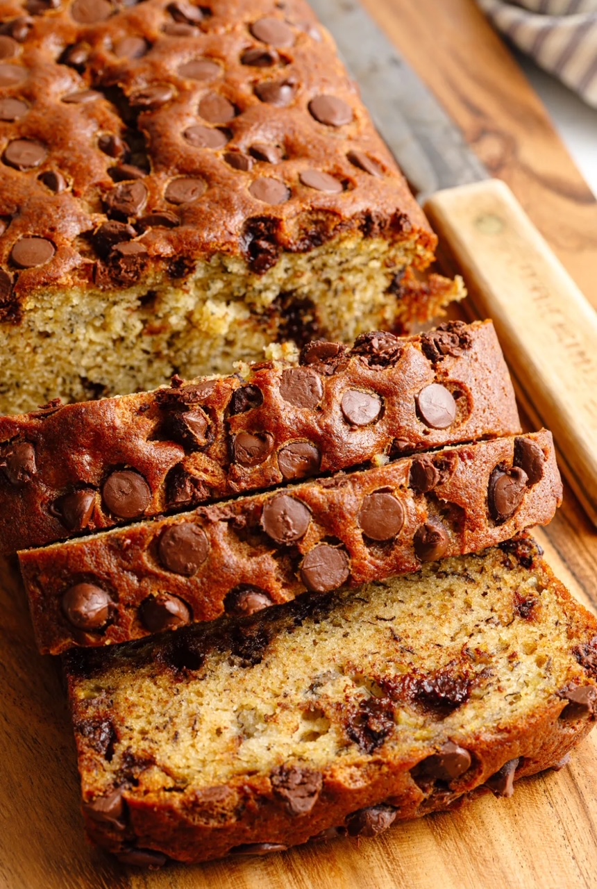 Chocolate Chip Banana Bread Chocolate Chip Banana Bread on a cutting board, sliced, with a knife next to the bread.